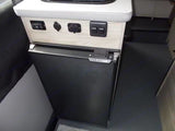 RV rental: Compact fridge & utility panel with outlets/switches for comfort on your journey.