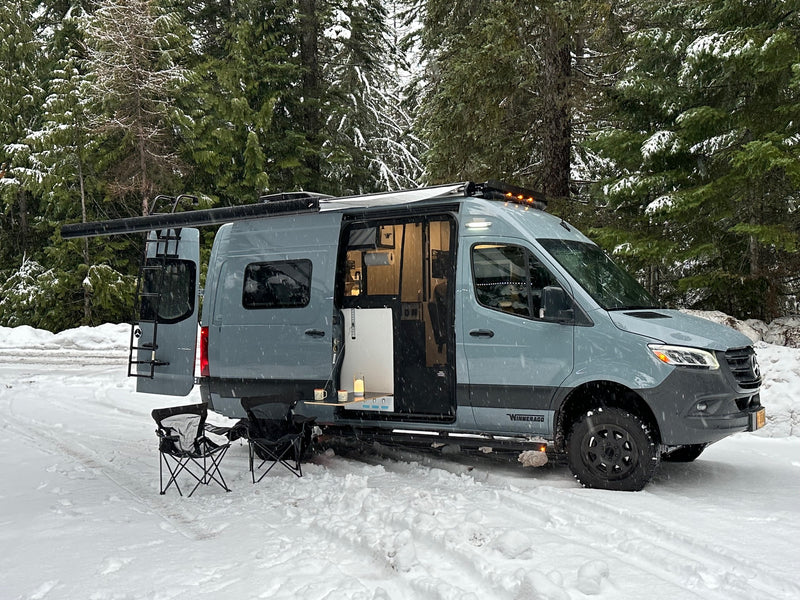  and "Step Into The Wild" mugs ready for adventure.|Experience comfort in this RV rental! Interior features a dining table — photo 9