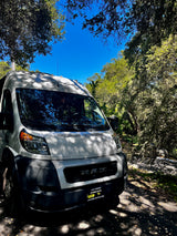 White Ram ProMaster van, ideal for rv rental adventures, parked under shaded trees.