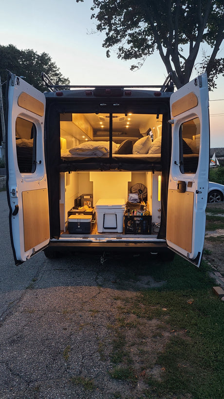 Our RV rental campervan offers illuminated comfort: upper bed, lower storage, perfect for van life adventures.