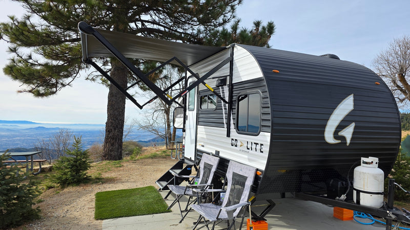Scenic rv rental campsite with a travel trailer, chairs, and an extended awning overlooking a panoramic mountain and valley view. — photo 20