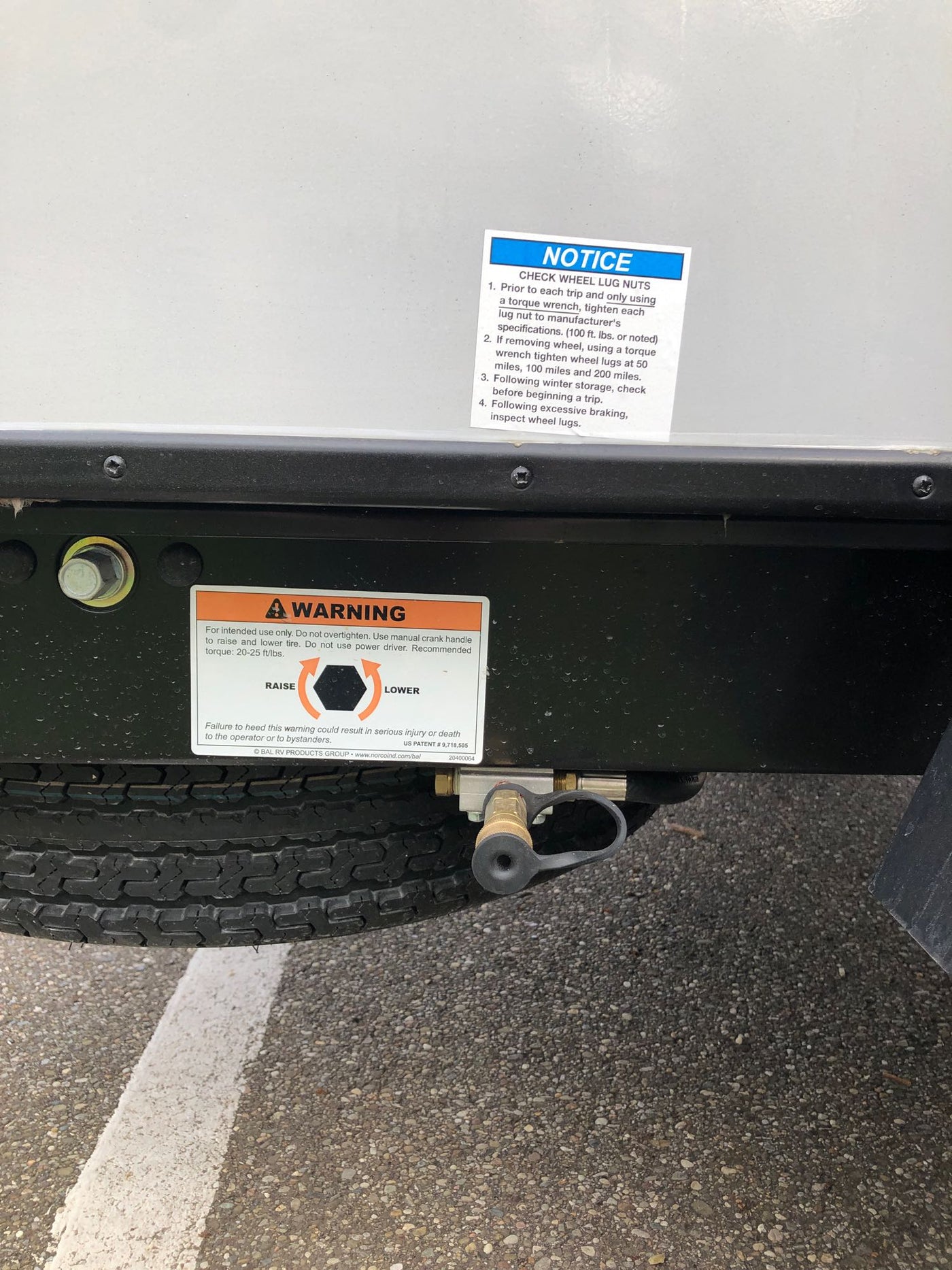 Essential safety warnings on an RV rental undercarriage, detailing wheel lug nut checks and tire raising. — photo 9