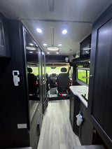  custom camper van with knobby tires and an awning