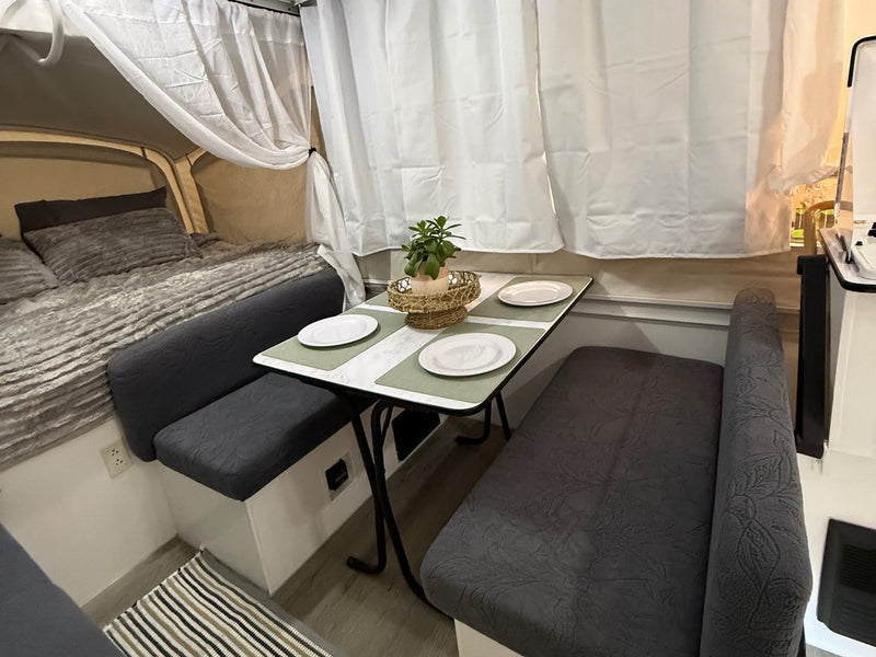  and white privacy curtains.|Experience a charming RV rental interior. This cozy camper features a comfortable bed — photo 4