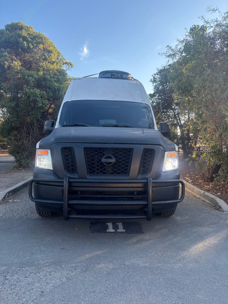 Front view of a white and black Nissan rv rental camper van, parked in spot 11, ready for an outdoor adventure. — photo 3