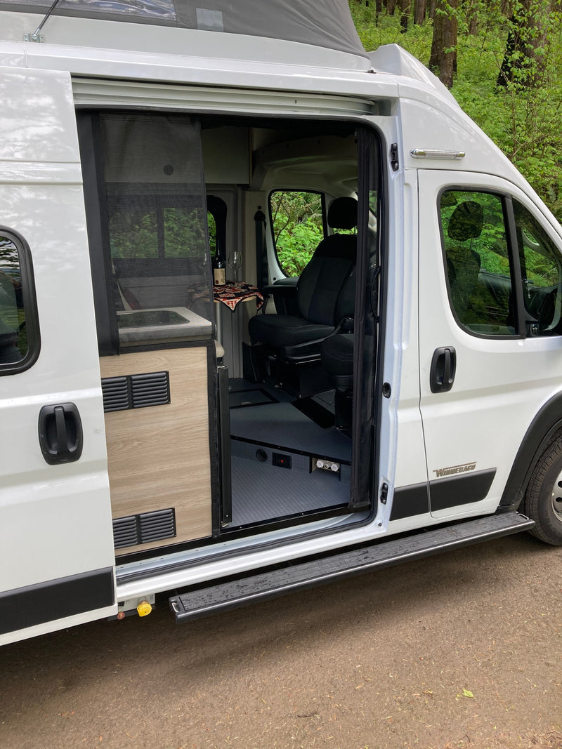  parked on a dirt road in a green forest.|White RV rental with pop-top enjoying a peaceful forest campsite — photo 11