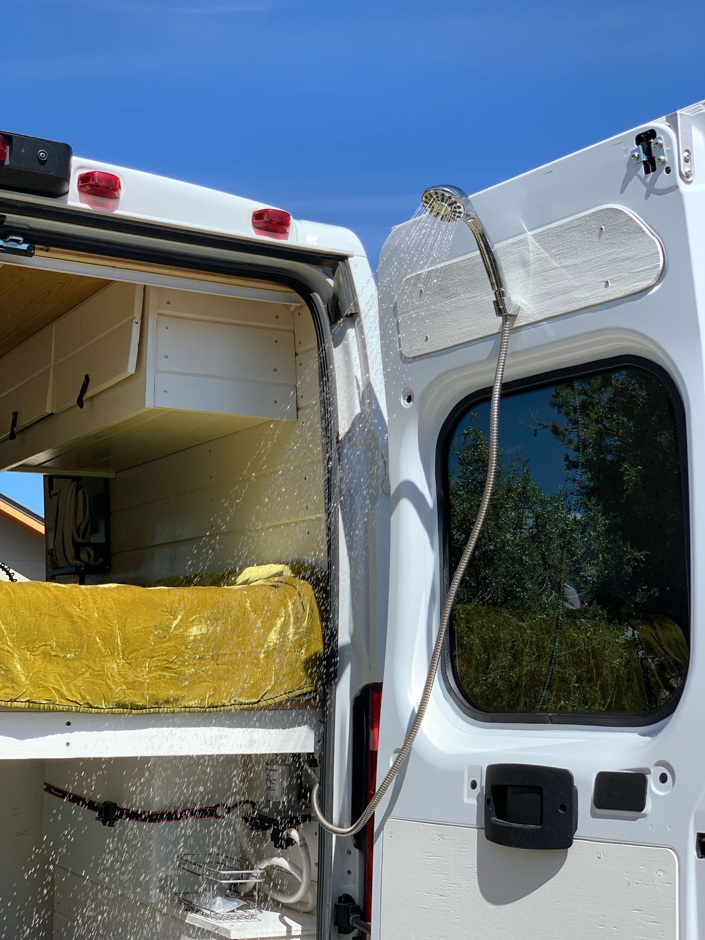 Experience mobile living convenience! This RV rental features an outdoor shower from its rear doors, perfect for van life.
