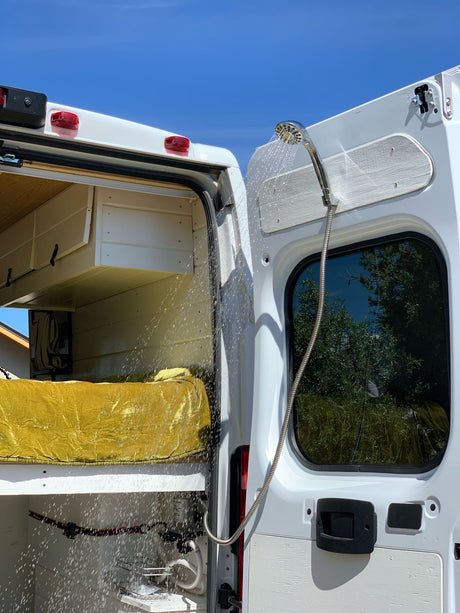 Experience mobile living convenience! This RV rental features an outdoor shower from its rear doors, perfect for van life.