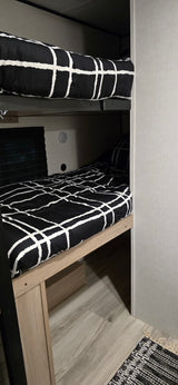 Modern black and white bunk beds inside a cozy RV rental, perfect for family adventures.
