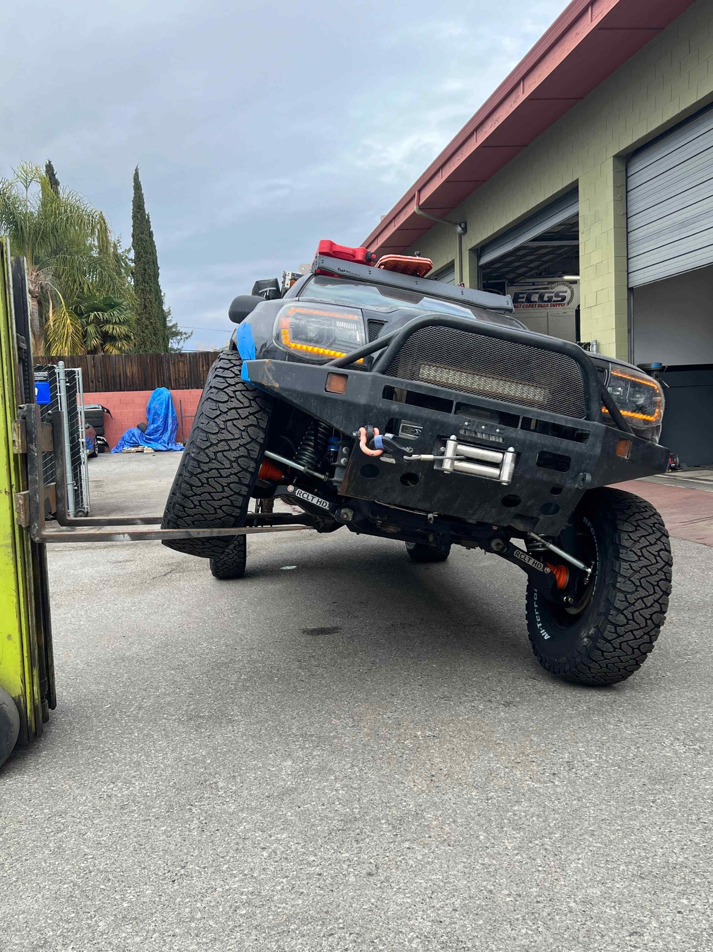 Rugged off-road truck on a forklift, demonstrating extreme suspension articulation. Great for demanding rv rental adventures.