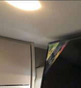 RV rental interior: A TV with a colorful label sits beside a built-in cabinet or refrigerator, showcasing efficient use of compact space.
