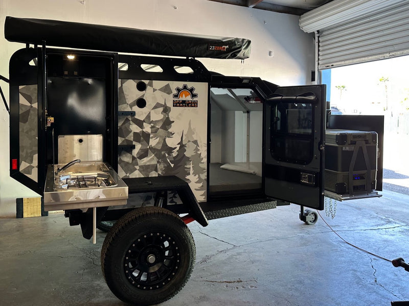 This off-grid camper features a slide-out kitchen, interior bed, fridge, and awning, ideal for RV rental. — photo 6