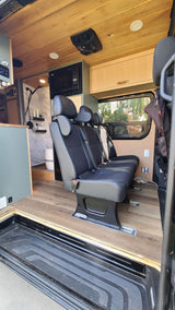 Modern RV rental interior with passenger bench seating, integrated microwave, and built-in shower. Ready for travel.