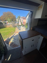 Inside a comfy RV rental, gazing out at a charming backyard and sunny patio. Your next road trip awaits!