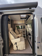 Spacious RV rental interior with comfy quilted seats, ladder to bunk, and modern design.