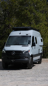 Light grey Mercedes-Benz Sprinter camper van with off-road tires, perfect for an RV rental nature escape.