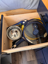 This RV rental drawer is efficiently packed with kitchen essentials: a pot, pan with lid, and towels for cooking on the go.
