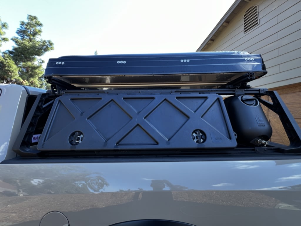  and spare tire. Perfect for your next rv rental adventure.|This RV rental with a ROOFNEST rooftop tent is ready for desert adventures under a clear sky.|Overlanding truck bed with black rooftop tent — photo 2