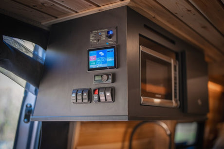 This RV rental's integrated power management system with its detailed control panel, switches, and compact microwave.