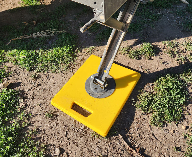 RV rental setup: A yellow pad stabilizes an RV jack on dirt, essential for level camping. — photo 18