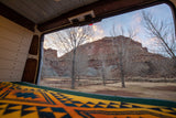 Sunrise from our cozy RV rental, revealing stunning red rock cliffs and a peaceful winter campground scene through the back door.