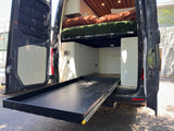 RV rental camper van interior featuring a pull-out gear tray, bed, and custom storage layout.