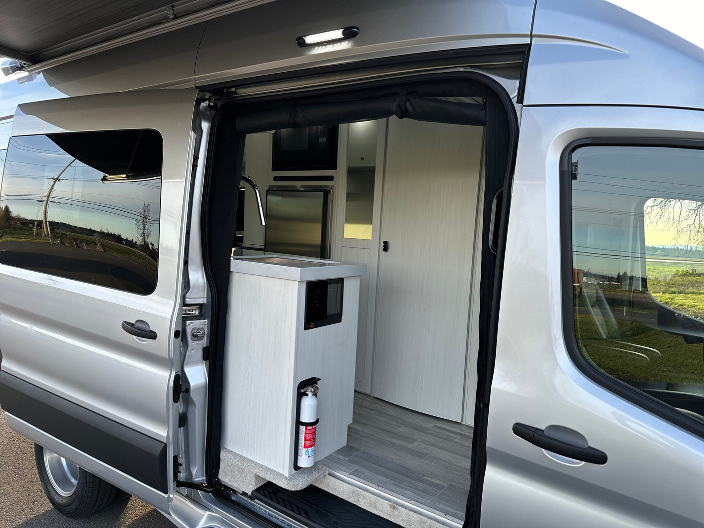 Explore comfort in this modern rv rental camper van interior, featuring a compact kitchen & ample storage.