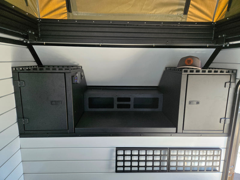 RV rental: Camper interior with dark storage cabinets, central platform, control panel, and a pop-top tent section above. — photo 5