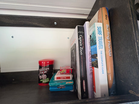 Compact entertainment for your RV rental adventure: surf books, Florida guides, and travel-sized games like Yahtzee & Uno.