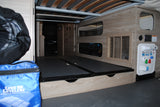 RV rental rear storage area features utility panel (water/electric), vented interior, and bed frame above.