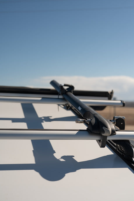 RV rental ready for winter adventures: Thule ski/snowboard rack mounted on roof crossbars. Perfect for outdoor gear.
