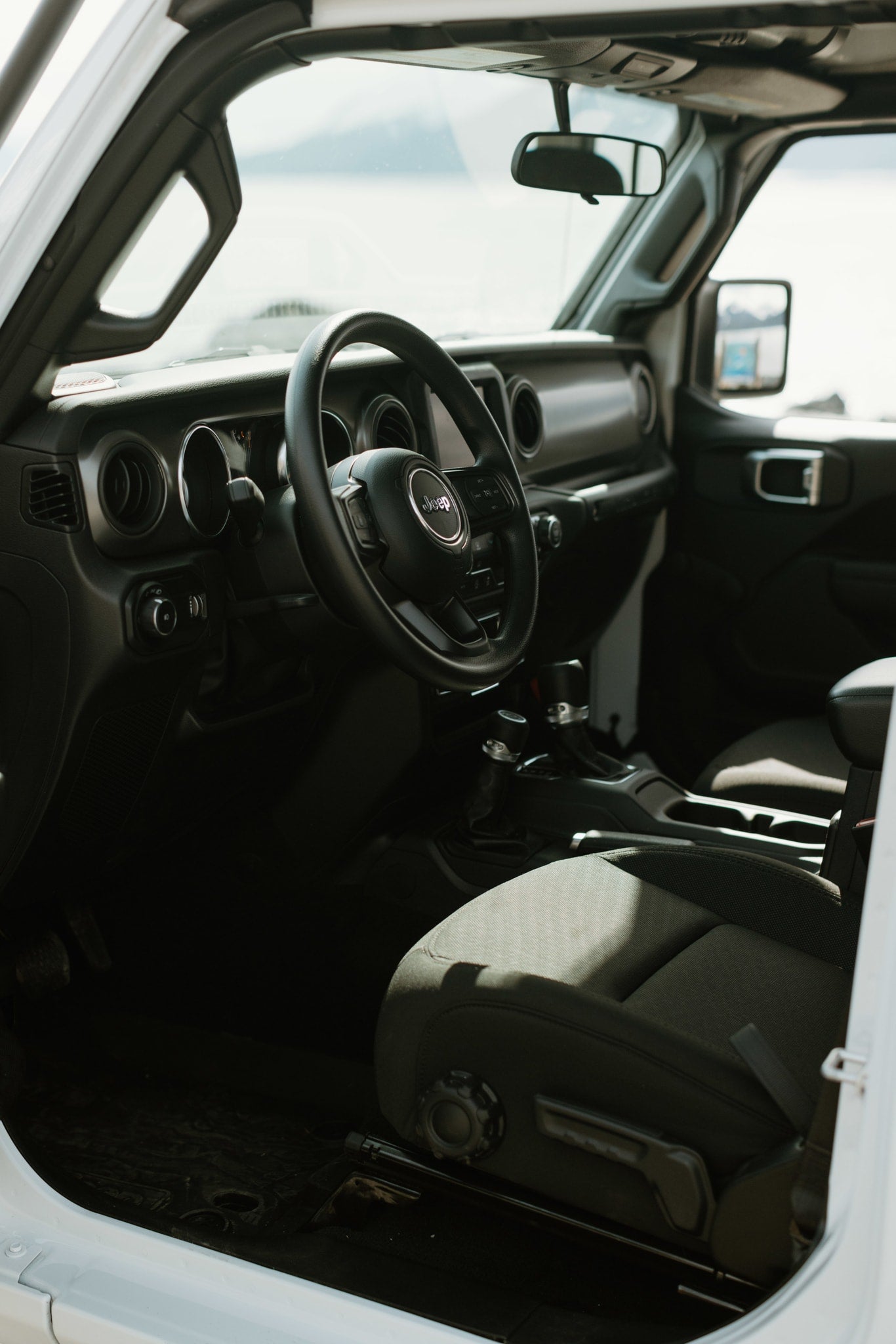 Bright Jeep interior: steering wheel, dashboard, front seat. Perfect for outdoor RV rental adventures. — photo 9
