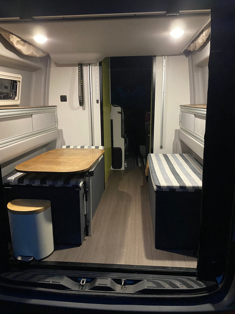  lights illuminating the sand.|Cozy rv rental camper van interior featuring bench seating — photo 7