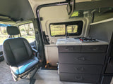 Inside an RV rental: features include a modern kitchen with sink/stovetop & swiveling passenger seat, ready for adventure.