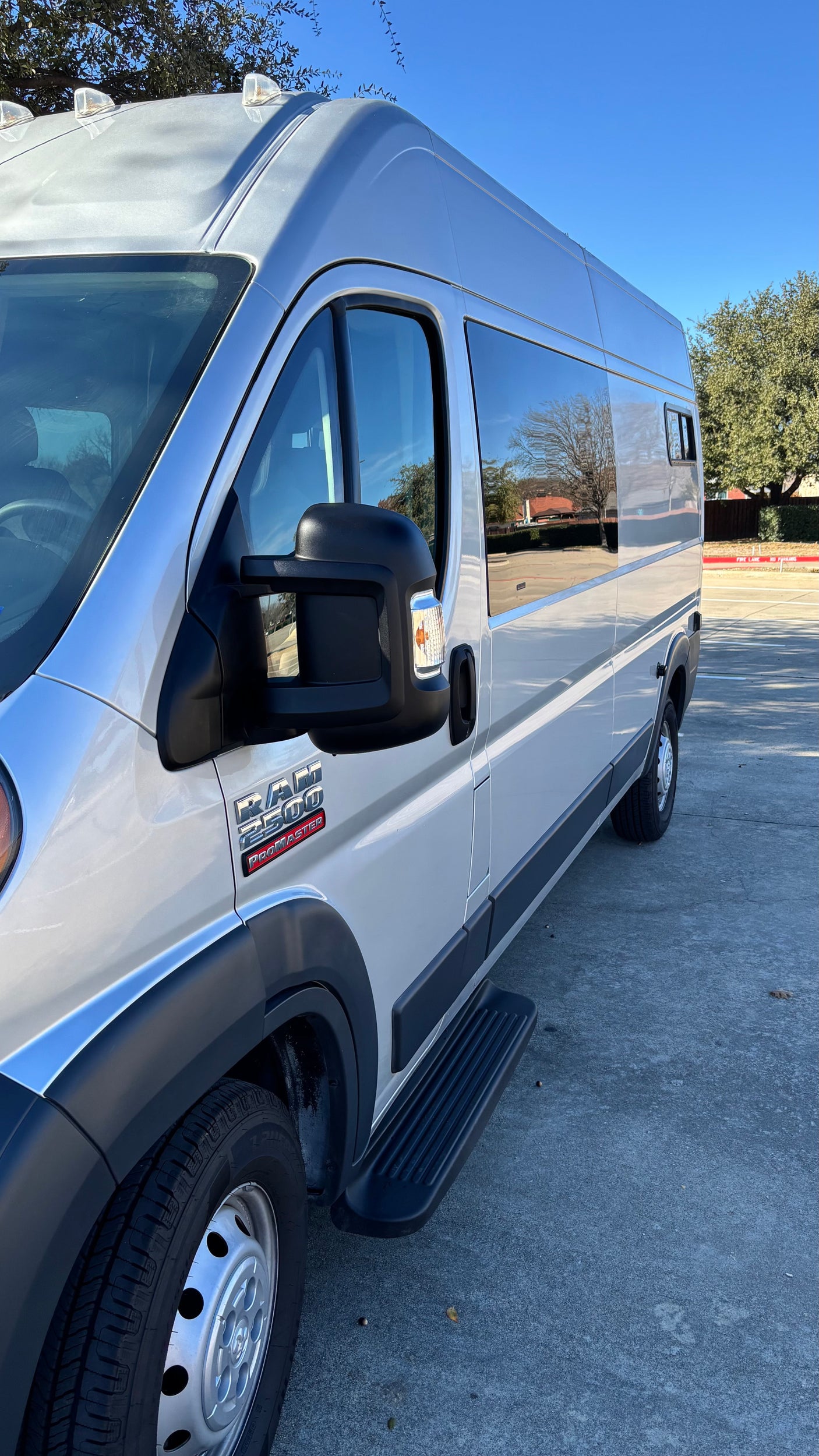 Side view of a silver Ram ProMaster 2500 van with a step rail, an excellent option for an RV rental.