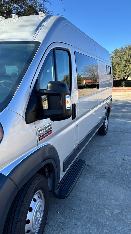 Side view of a silver Ram ProMaster 2500 van with a step rail, an excellent option for an RV rental.