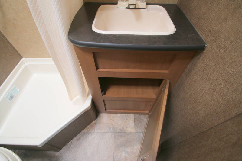  and adjacent mini-kitchen with a cooktop.|RV rental: Overhead light wood cabinet with door — photo 11