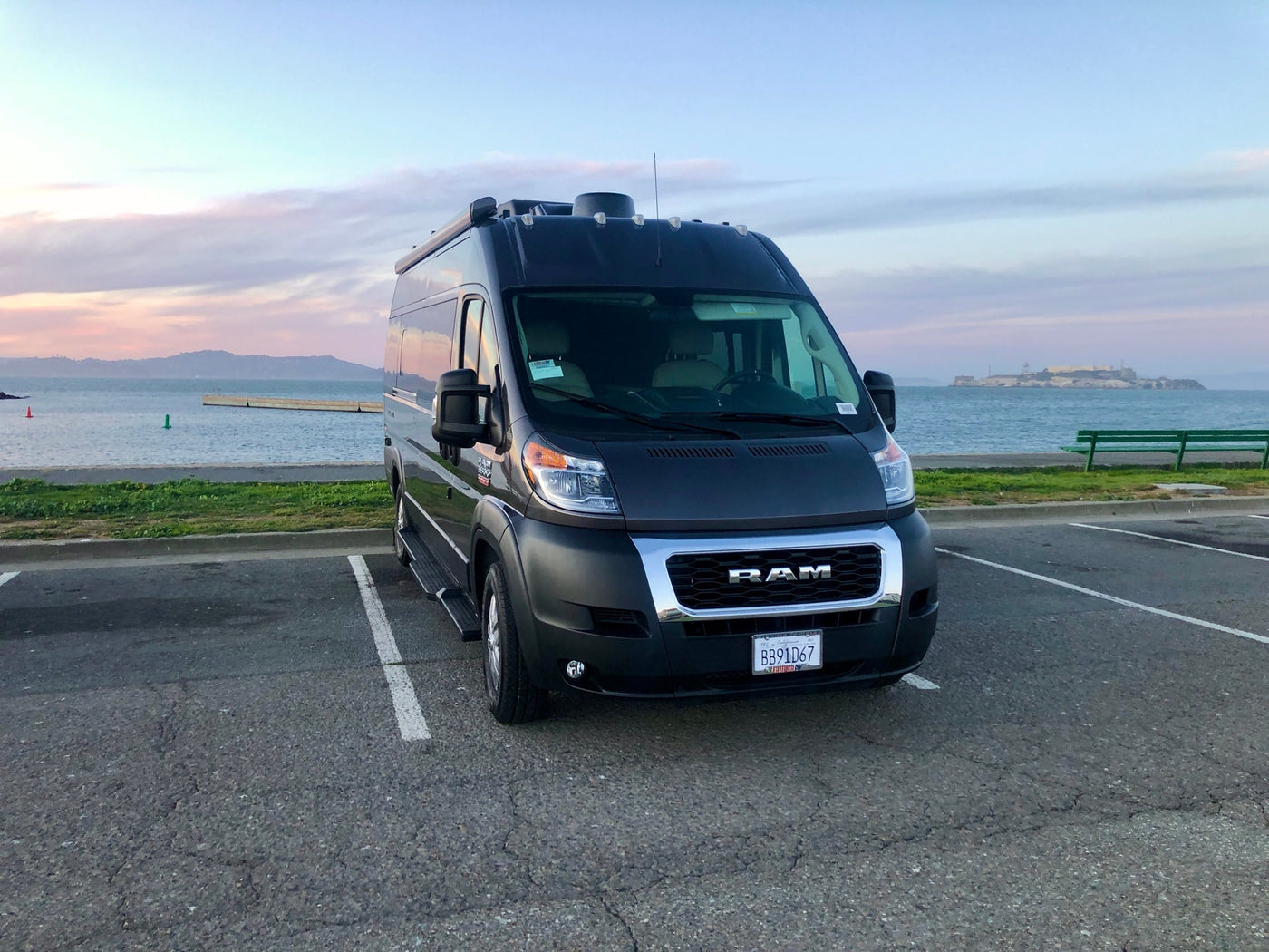 Dark gray Ram ProMaster rv rental by San Francisco Bay, with Alcatraz under a beautiful pastel sky. — photo 14