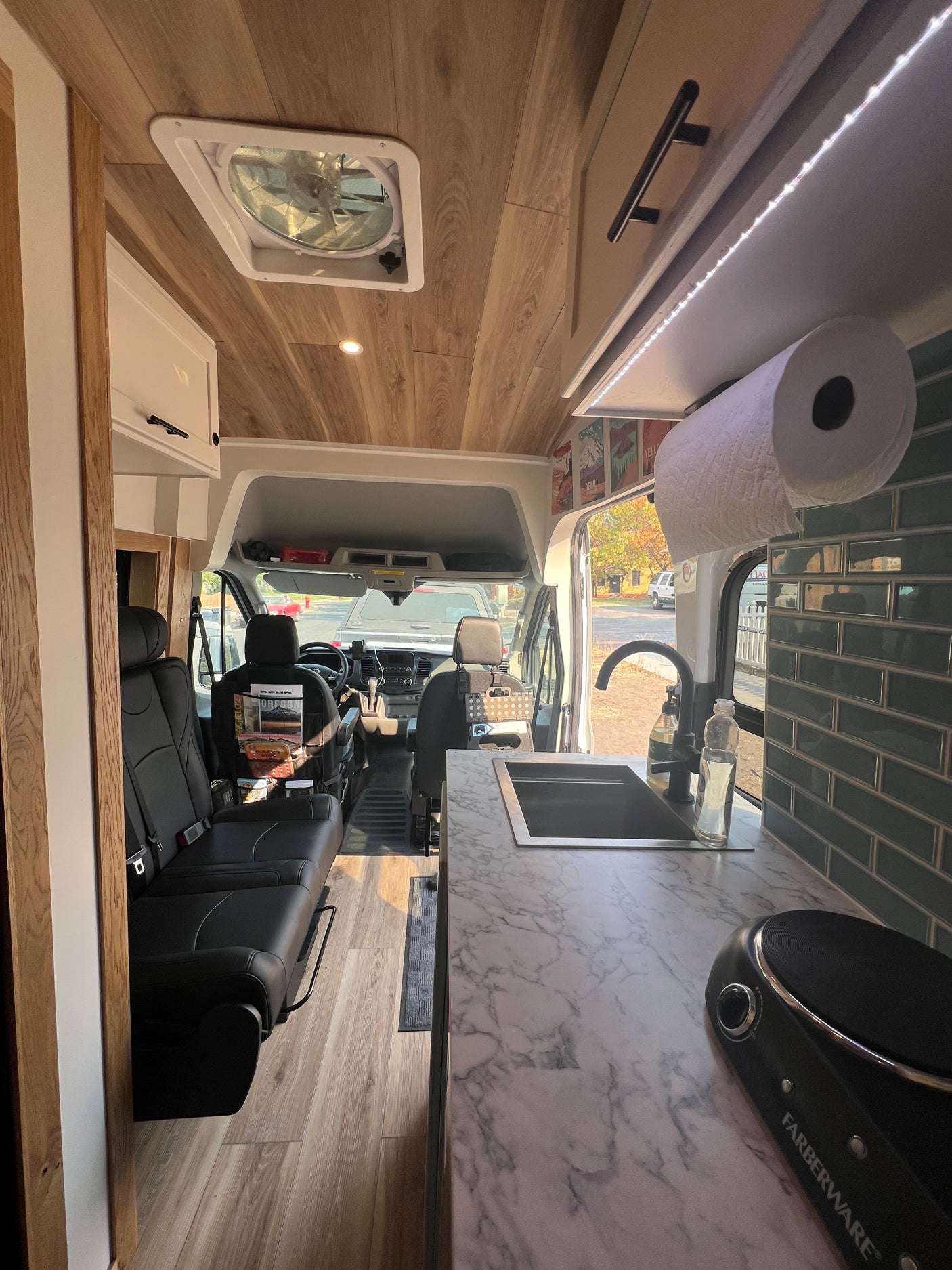 Experience comfort in this RV rental: spacious interior features a modern kitchen, comfortable seating, and wood plank ceiling.