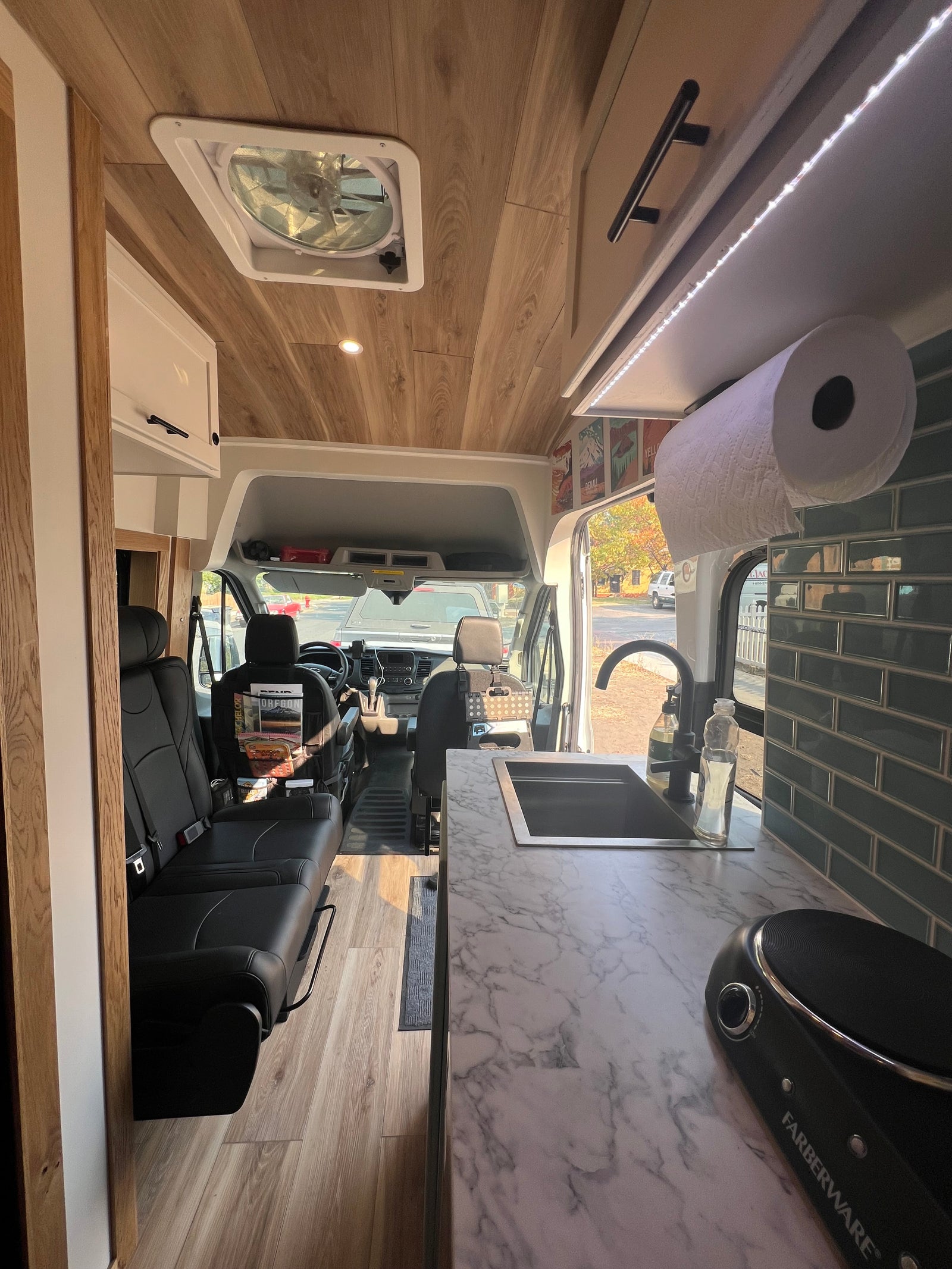 Experience comfort in this RV rental: spacious interior features a modern kitchen, comfortable seating, and wood plank ceiling.