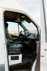 Spacious van interior of an RV rental, featuring driver's cabin, comfortable seats, and modern dashboard. Ready for adventure!
