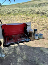 Outdoor cooking with a Teton 2X stove & coffee mugs at an RV rental campsite. Surrounded by sagebrush landscape.