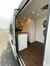 Peek inside this stylish rv rental: kitchen, shower, and cozy living space, perfect for your beach travel adventures.