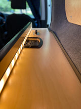 RV rental comfort: illuminated wood counter with LED lights, power outlets & controls. Plush wall fabric adds warmth.