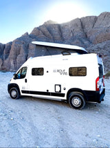 White Rove Vans camper van with a pop-top roof, parked in a sunny mountain desert, ideal for RV rental.