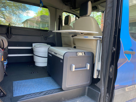 RV rental 'Vandoit' van interior shows Dometic fridge, toilet, and Lagun table, ideal for adventure travel.