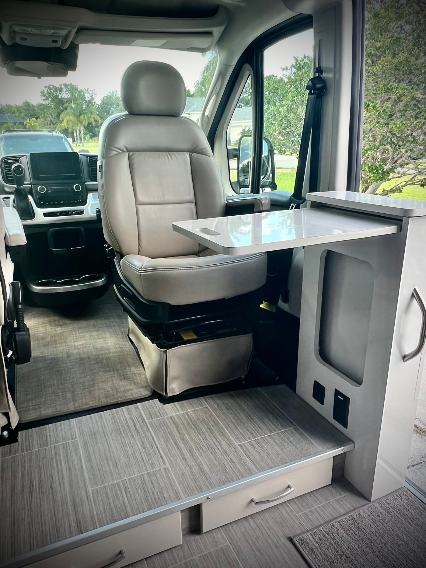  and a built-in counter with a microwave unit.|RV rental kitchen: A chrome faucet with a Brita filter sits on a light counter next to a black induction cooktop.|This RV rental offers a serene waterfront view. Inside — photo 15