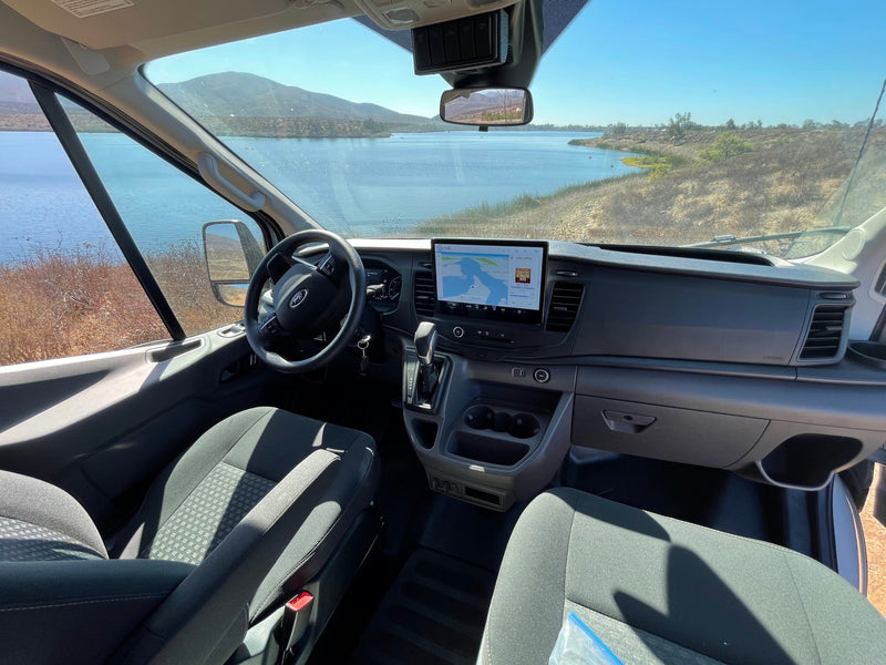 Inside an RV rental, showing the Ford van dashboard, large touchscreen map, and a beautiful lake view outside. — photo 18
