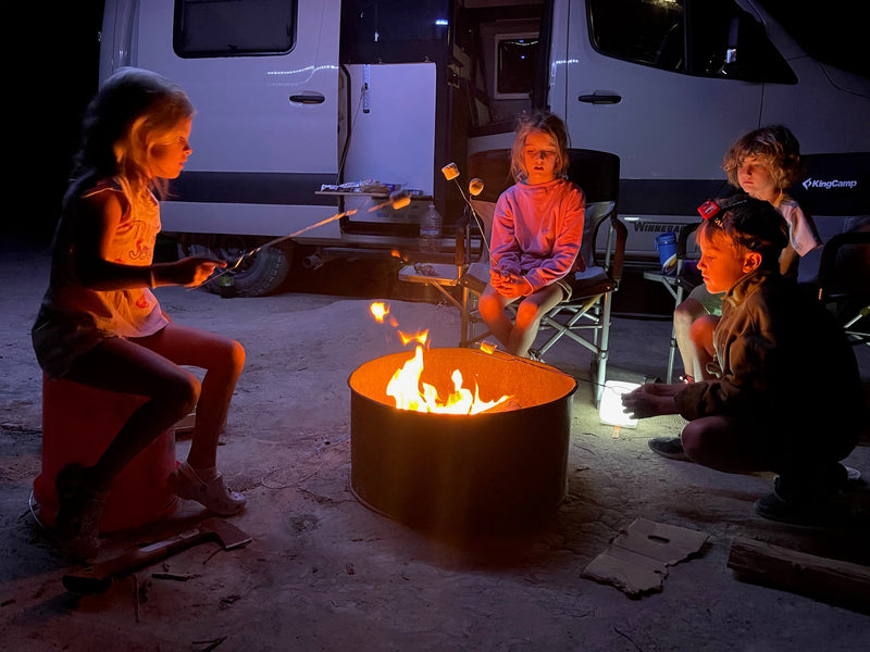 Campfire fun! Kids gather, roasting marshmallows by an RV rental. A cozy night of family camping memories. — photo 4