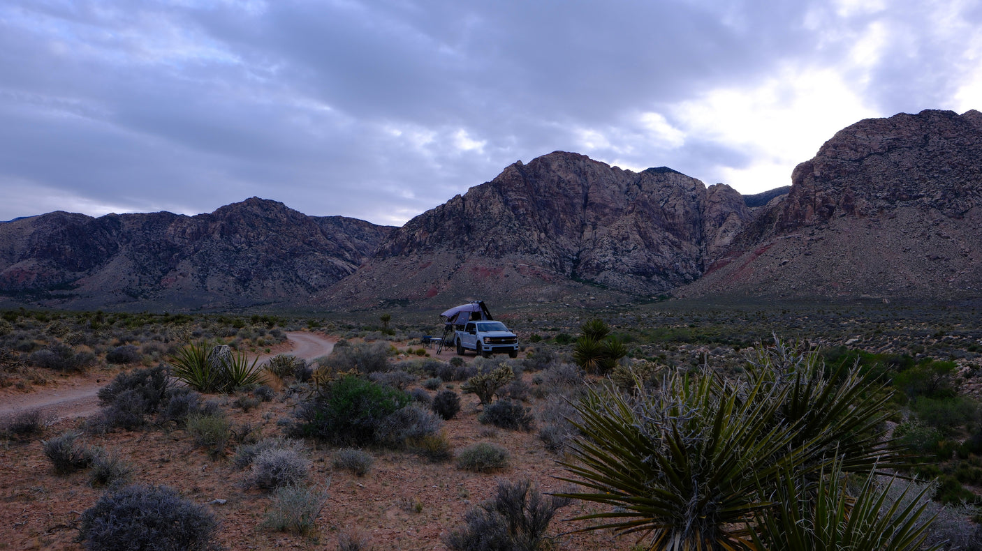 Explore nature with an RV rental: a truck with a rooftop tent ready for mountain camping in the desert.